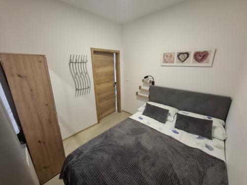 1 dormitorio con 1 cama grande y puerta de madera en Prenočišča Dany APARTMA 2, en Dravograd