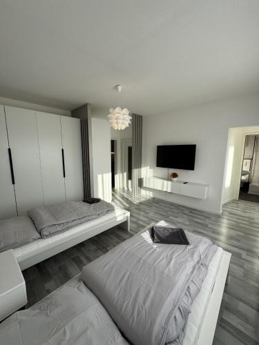 a bedroom with two beds and a flat screen tv at Schönes Apartment für 5 Personen nahe Zentrum & Borussia Park MG77 in Mönchengladbach