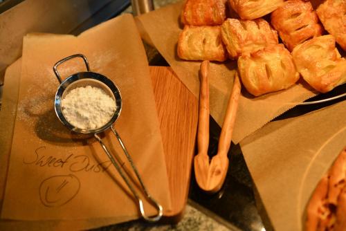 un tavolo sormontato da pinze e un piatto di pasticcini di ScanHotels Stadthafen a Rostock