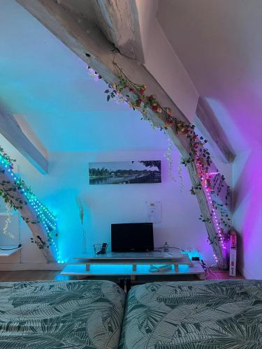 Zimmer mit einem Bett und einem Tisch mit Beleuchtung in der Unterkunft O'Jade 2 Lits Proche Gare Orléans et Fleury in Orléans