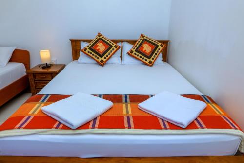 un dormitorio con una cama con sábanas y almohadas blancas en SaRu Holiday Apartments - 2BR 6 Guests, en Kandy