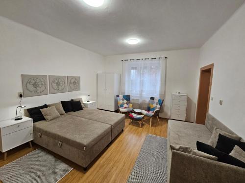 ein Wohnzimmer mit einem Bett und einer Couch in der Unterkunft Harmonia Budget apartman in Dunajská Streda