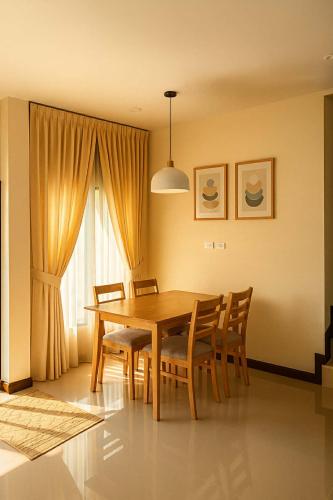 una sala da pranzo con tavolo e sedie in legno di Almas home a Hat Yai