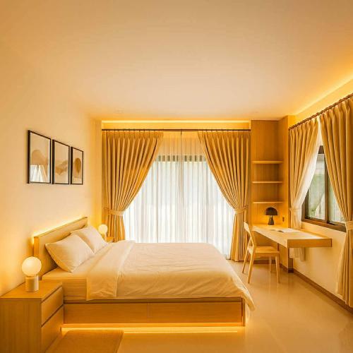 una camera da letto con un letto, una scrivania e una finestra di Almas home a Hat Yai