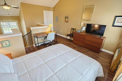 ein Schlafzimmer mit Bett, Schreibtisch und Fernseher in der Unterkunft Suites On Chocolate - The Theater in Hershey