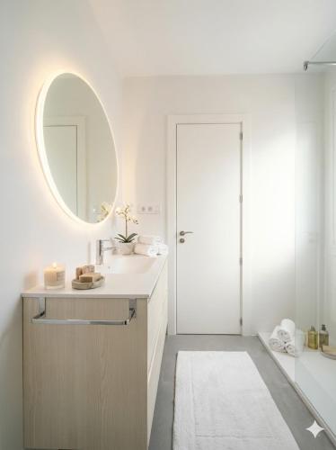 a white bathroom with a sink and a mirror at Céntrico Apartamento con parking in A Coruña