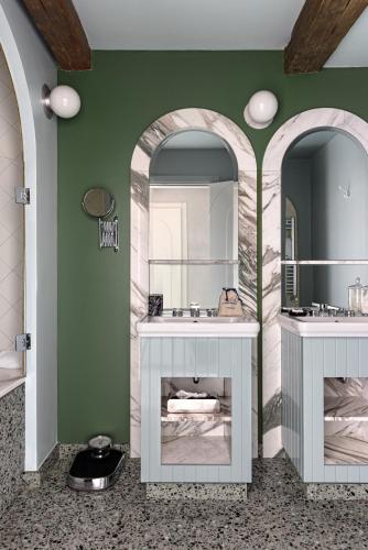 a bathroom with two sinks and two mirrors at Il Palazzo Experimental in Venice
