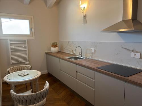 cocina con encimera, fregadero y mesa en My Maison 49, en Empoli