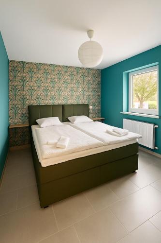 a bedroom with a large bed with blue walls at Eifeltraum in Daun