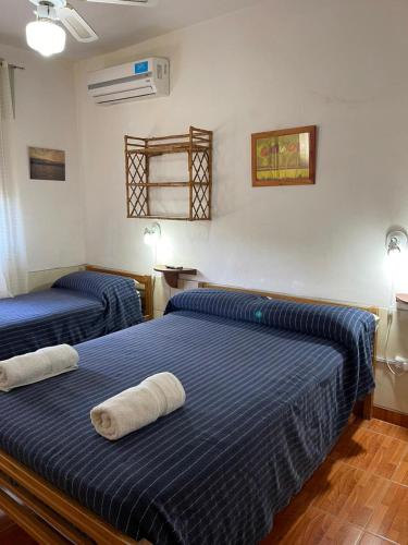 twee bedden in een kamer met blauwe lakens bij Are-Kepay in Villa Carlos Paz