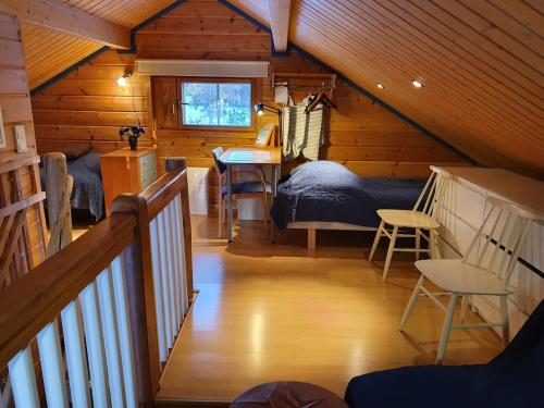 a attic room with a bedroom and a bed and a table at Yläkolo - A functional cottage in a good location in Saariselka