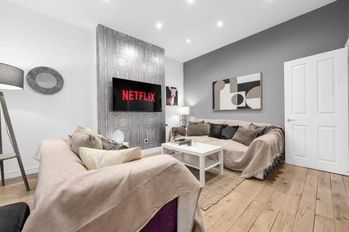 een woonkamer met een bank en een tafel bij 4 Bedroom House With Cinema Room by City SuperHost in Hale