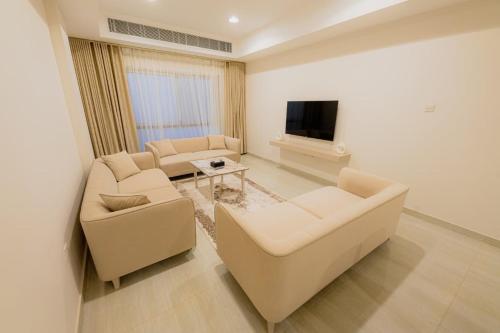 un salon avec deux canapés et une télévision dans l'établissement إطلالة الشاطئ, à Dammam