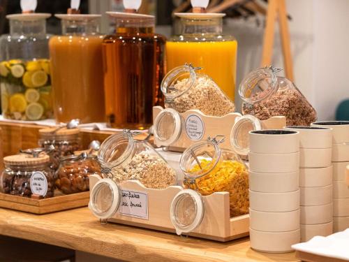a table with containers of food and jars of orange juice at Novotel Paris Centre Gare Montparnasse in Paris