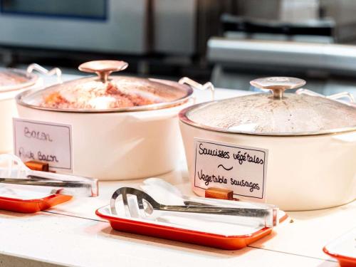 three pots of food sitting on a counter at Novotel Paris Centre Gare Montparnasse in Paris
