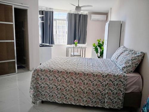 een slaapkamer met een bed en een tafel erin bij Tropical Loft in Niterói