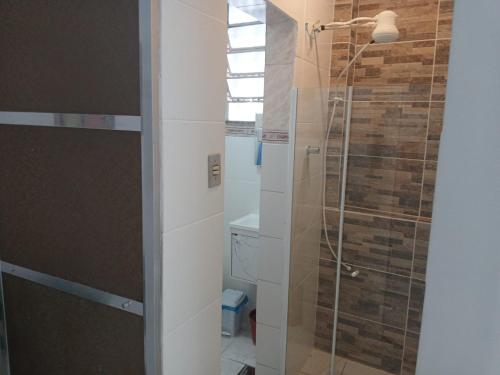 een badkamer met een douche met een glazen deur bij Tropical Loft in Niterói