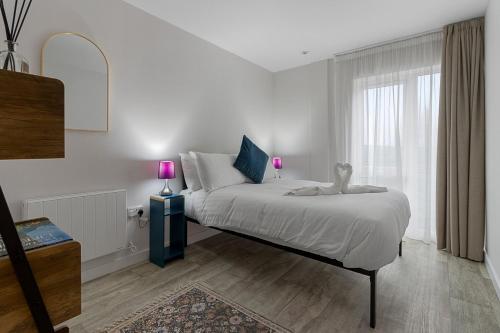ein Schlafzimmer mit einem Bett mit zwei Lampen in der Unterkunft City Pulse Apartment- Short Stays UK in Exeter