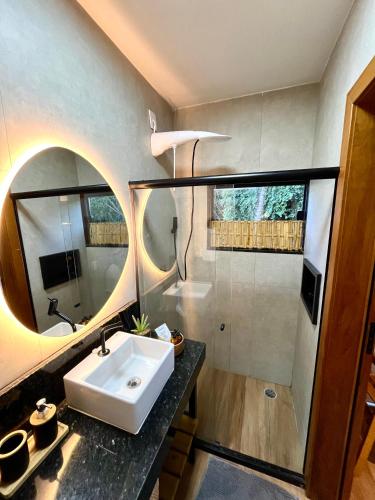 a bathroom with a sink and a mirror at Villa Manah in Itaúnas