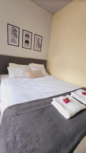 a bedroom with a large white bed with towels on it at Sao Luis Praia Studio in São Luís