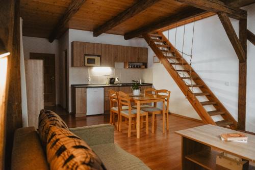 Una sala de estar con un sofá y una mesa y una cocina. en Penzion U Skutilů, en Pilníkov