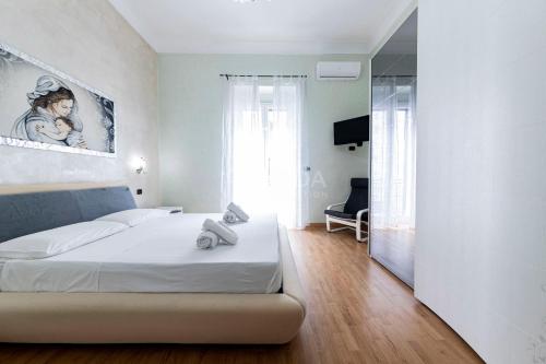 ein weißes Schlafzimmer mit einem Bett und einem Fenster in der Unterkunft CORAL BAY Apartment in Porto Cesareo