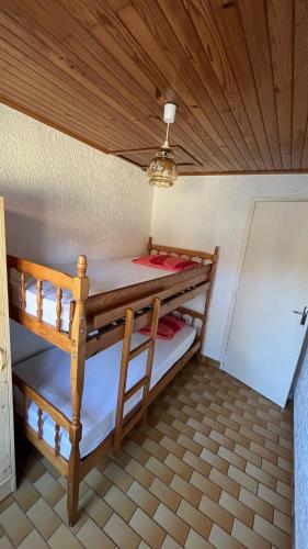 two bunk beds in a room with a wooden ceiling at Le Tuc de Rose in Mimizan