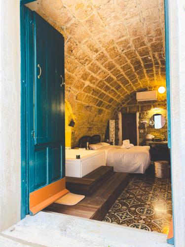 een badkamer met een bad en een kamer met twee bedden bij Corte Lirice Paradiso in Gioia del Colle