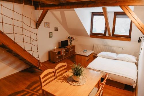 Habitación en el ático con cama, mesa y escritorio. en Penzion U Skutilů, en Pilníkov