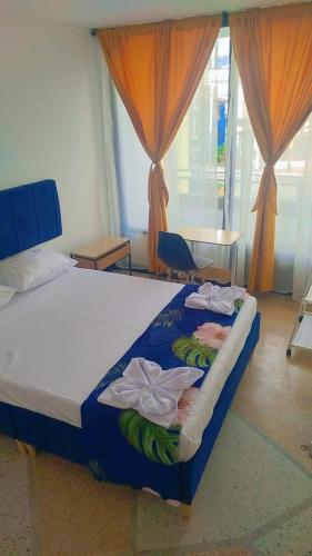 a bedroom with a bed with towels on it at Colibri Hostel in Armenia