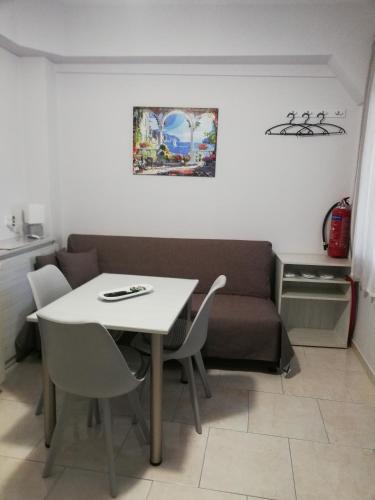 a table and chairs and a couch in a room at Studio B1 in Mytilene