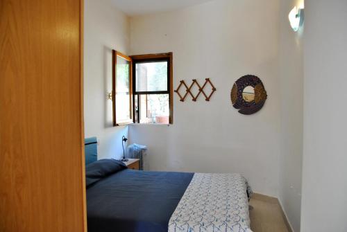 a bedroom with a bed and a window at Casa Simon tra mare e natura in Sperlonga