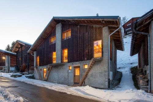 un edificio con luces encendidas en la nieve en Stadel Alpenstern mit Wellnessbereich, en Blitzingen