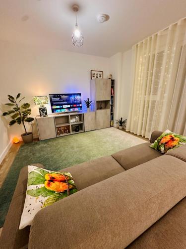 a living room with a couch and a flat screen tv at Luxury New Studio by Excel London City Airport in London