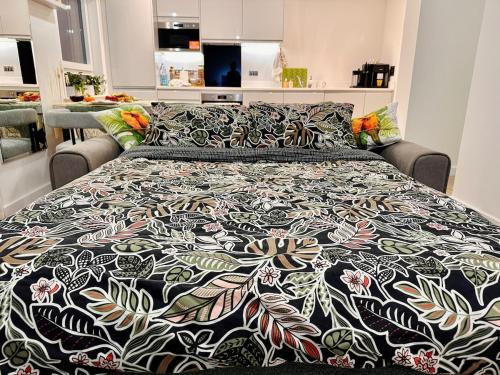 a bed with a black and white comforter at Luxury New Studio by Excel London City Airport in London