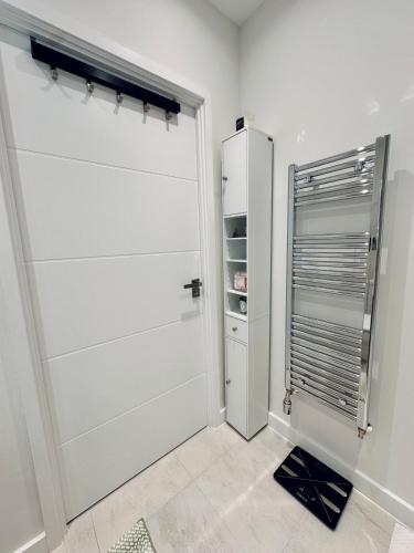 a white closet with a door in a room at Luxury New Studio by Excel London City Airport in London