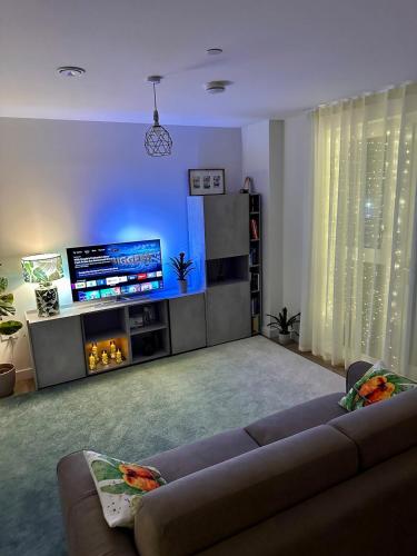 a living room with a couch and a flat screen tv at Luxury New Studio by Excel London City Airport in London