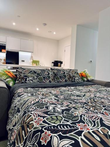 a large bed with a patterned blanket on it at Luxury New Studio by Excel London City Airport in London