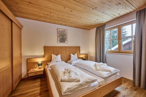 a bedroom with a large bed with white sheets at Appartement Omesberg 1 in Lech am Arlberg