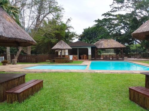 een zwembad met een prieel en een resort bij 115 Eden wilds in Port Edward