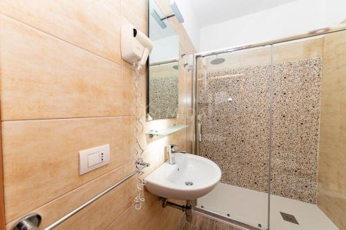 een badkamer met een wastafel en een spiegel bij Giorni Salentini in Torre Lapillo