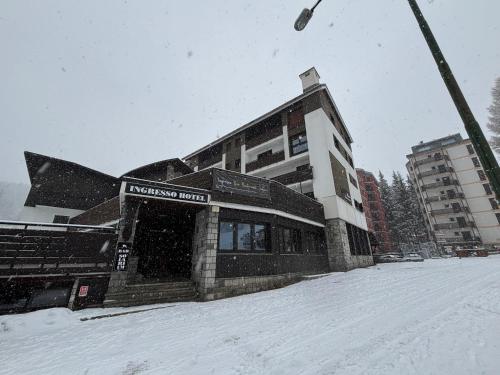 un edificio en la nieve junto a una luz de la calle en Hotel Arlecchino - Dada Hotels, en Madesimo