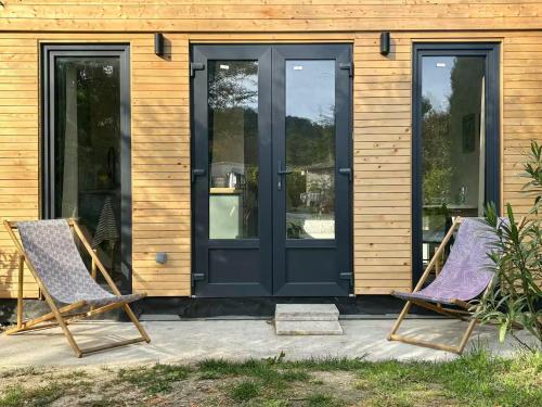 two chairs on a patio in front of a house at Studio tout confort dans la campagne aixoise in Le Puy-Sainte-Réparade