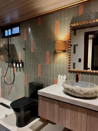 a bathroom with a sink and a toilet and a mirror at Conga Boutique Hotel in Puerto Viejo