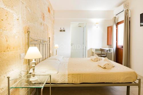 a bedroom with a bed and a table with a lamp at InCentro b&b in Porto Cesareo