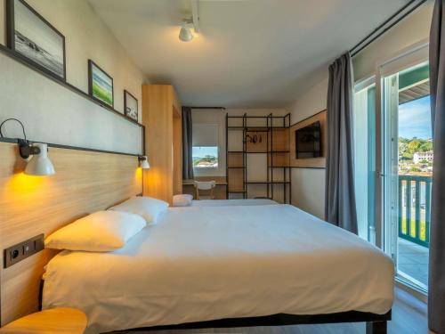 シブールにあるイビス シブール サン ジャン ド リュズの大きなベッドと大きな窓のある寝室