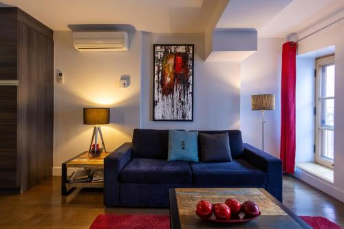 ein Wohnzimmer mit einem blauen Sofa und einem Tisch in der Unterkunft Les Immeubles Charlevoix - Le 1166 in Québec