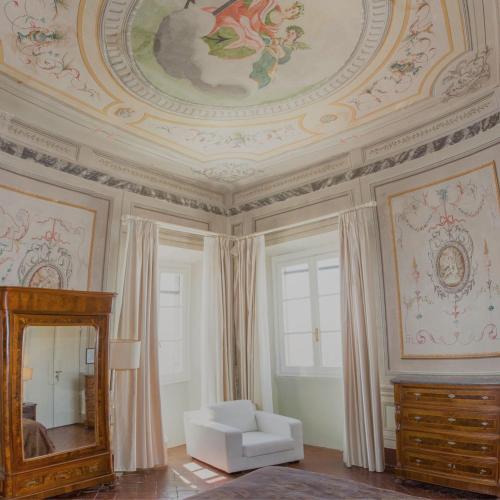 a room with a ceiling with a mirror and a chair at Hotel Villa Sermolli in Borgo a Buggiano