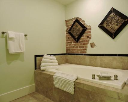 a bathroom with a bath tub with towels at The Valley in Vicksburg