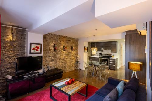 ein Wohnzimmer mit Sofa und Fernseher in der Unterkunft Les Immeubles Charlevoix - Le 1166 in Québec